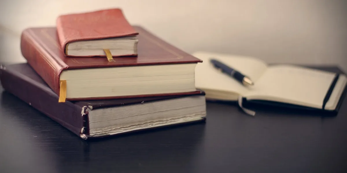 Livros jurídicos empilhados sobre a mesa